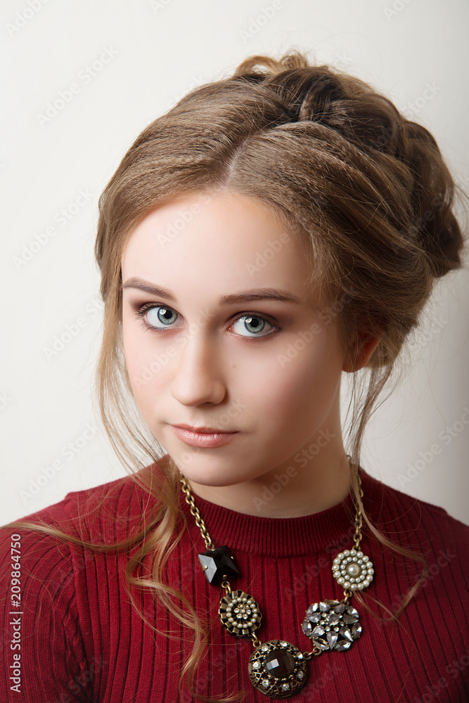 Brown-haired girl with hair and makeup in a Burgundy dress on a gray  background close-up. Stock Photo | Adobe Stock