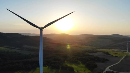 panoramic aerial view of wind turbines with rotating blades on summer fields with beautiful summer f