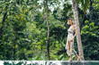 © LIGHTFIELD STUDIOS - attractive blond woman in dress walking near swimming pool with green plants on background, ubud, bali, indonesia