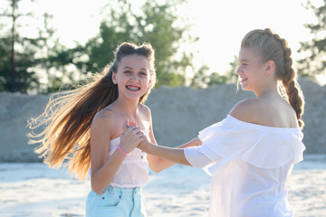 two funny teenage girls are all out on the sandy