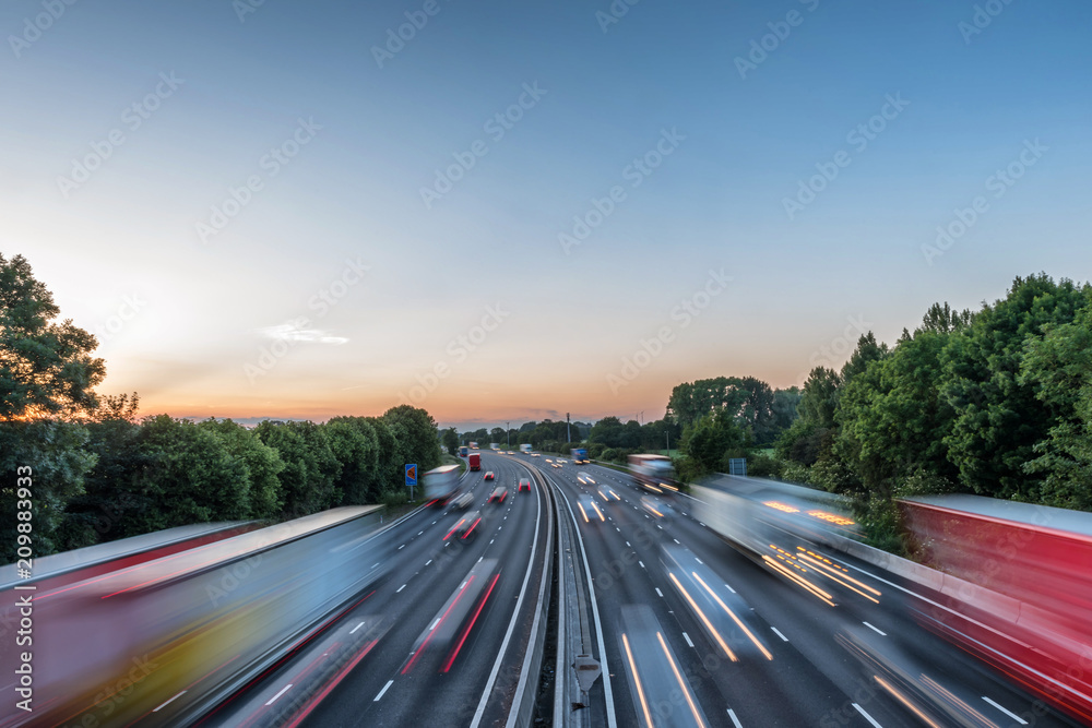 Sunset view heavy traffic moving at speed on UK motorway in England - obrazy, fototapety, plakaty 