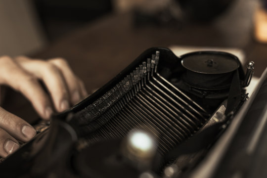 Young man's hands typing on an antique vintage typewriter