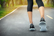 © sutthinon602 - Sports background, Runner feet running on road closeup on shoe, Sport woman running on road at sunrise, Fitness and workout wellness concept.
