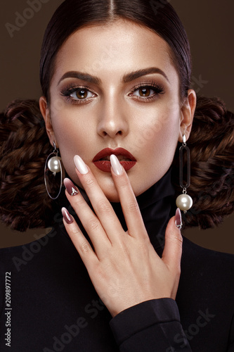 Fotografía Pretty girl with unusual hairstyle, bright makeup, red lips and manicure design