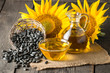 Sunflower oil and sunflower seeds in small sack on traditional rustic wooden background. Organic and eco food concept. Healthy food and fats.