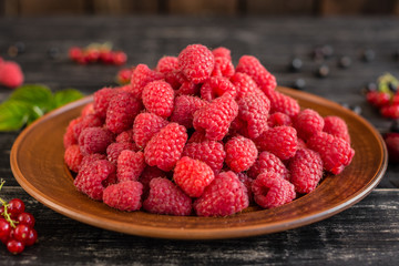 Tasty juicy sweet raspberry on a wooden background. It can be used as a background