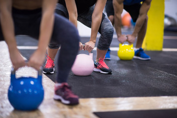 athletes doing exercises with kettlebells