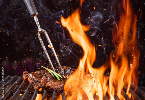 Cuadros en Lienzo Beef steak on the grill with flames