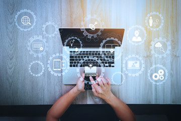 Poster - top view of Designer hand working with smart phone and laptop computer on wooden desk as responsive web design concept