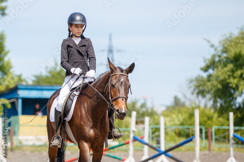 Fotografía Young girl riding horse on equestrian competition