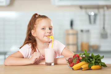 Poster - Little girl with glass of delicious milk shake in kitchen