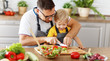 © JenkoAtaman - happy family father with son preparing vegetable salad