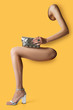 Parts of woman's body - hand, leg protrude through background. Concept of leather goods over complimentary color background.