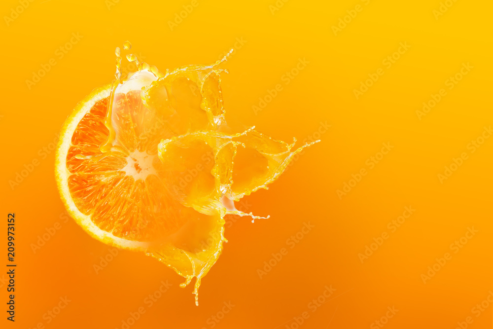 Fresh half slice of ripe orange fruit floation with splash drop on orange juice with copy space - obrazy, fototapety, plakaty 