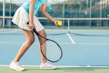Side View Low Section Of A Young Woman Wearing White Skirt And Tennis Shoes While Serving During Professional Match