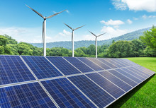 Solar Panels And Wind Turbines In Green Grass Field