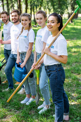 Wall Mural - young smiling volunteers standing in park