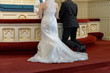 Bride and groom kneel on altar and saying oaths during wedding ceremony