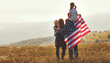 Leinwandbild Motiv happy family with flag of america USA at sunset outdoors