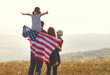© JenkoAtaman - happy family with flag of america USA at sunset outdoors