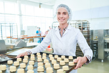 Confectioner In White Uniform Staying In Factory With Pastries And Smiling Looking At Camera