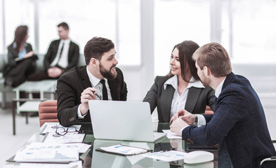 employees of the company work on laptop with information on the development of the company