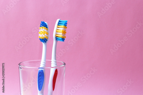 Fotografía toothbrushes in a glass on a colored background