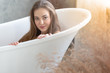 © thbangkok - Beautiful young girl in the bathroom lie down in a bathtub with copy space.