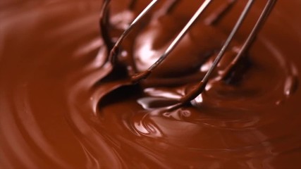 Wall Mural - Chocolate. Mixing melted dark chocolate with a whisk. Closeup of liquid hot chocolate swirl. Confectionery. Slow motion 4K UHD video 3840X2160