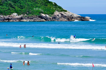 Wall Mural - Surfing on the blue sea with green island background