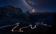 Traffic trails on mountain pass at night with milkyway