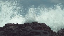 SLOW MOTION, CLOSE UP: Powerful Ocean Swell Hits The Tropical Black Rocky Shore And Splashes High In The Air. Spectacular View Of Dangerous Waves Crashing Into The Tropical Beach On Easter Island.