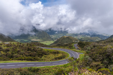 Winding Road on in Green Mountains with Clouds and Blue Sky