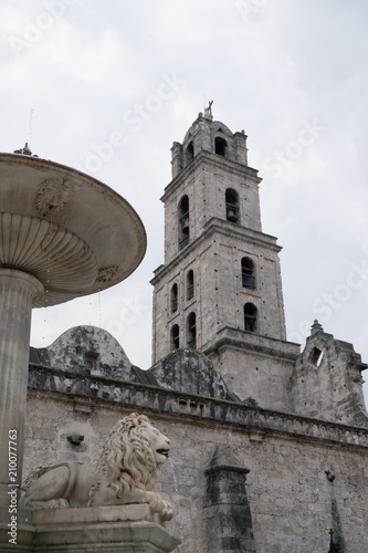 Fotografie, Obraz Looking at the belfry from behind the lion fountain of the Convento de San Francisco de Asís (Convent of San Francisco of Asis) in the Plaza of San Francisco in Old Town Havana (Habana Vieja)