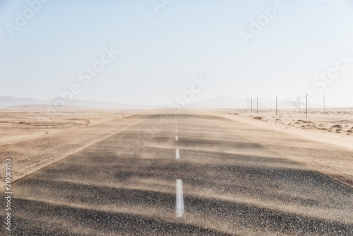 Cuadros en Lienzo Sand Storm Across Lonely Desert Road in Southern Namibia taken in January 2018