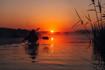 People kayaking down the river at sunrise 