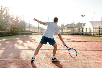 Wall Mural -  Man playing tennis in the morning in sunlight