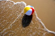 © vaitekune - Ball on sand beach with wave. Holiday beach ball on sea wave.