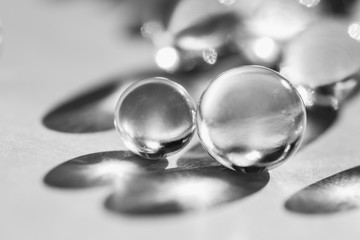 Little glass balls in direct sunlight, macro. Abstract background, black and white photo