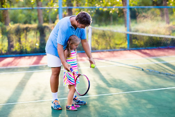 Family playing tennis on outdoor court