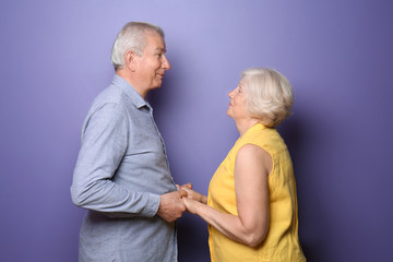 Wall Mural - happy senior couple on color background