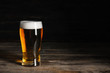 © Pixel-Shot - Glasses with cold beer on wooden table against dark background