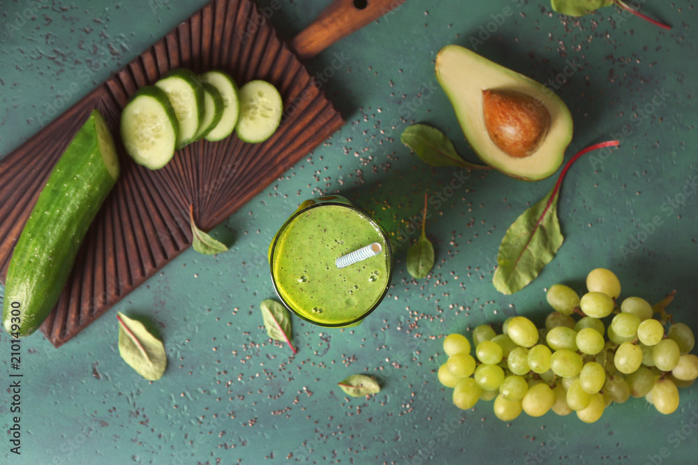 Glass of tasty smoothie and ingredients on table