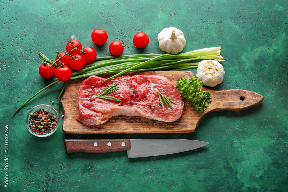 Wooden board with raw meat, herbs, spices and vegetables on table
