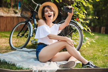 Wall Mural - Excited young girl taking selfie with mobile phone