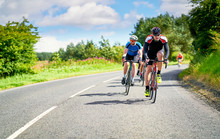 Cyclists Racing On Country Roads On A Sunny Day In The UK.