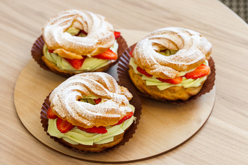 Wall Mural - Paris Brest, Cream puff rings with pistachio cream and fresh strawberry, traditional french choux pastry