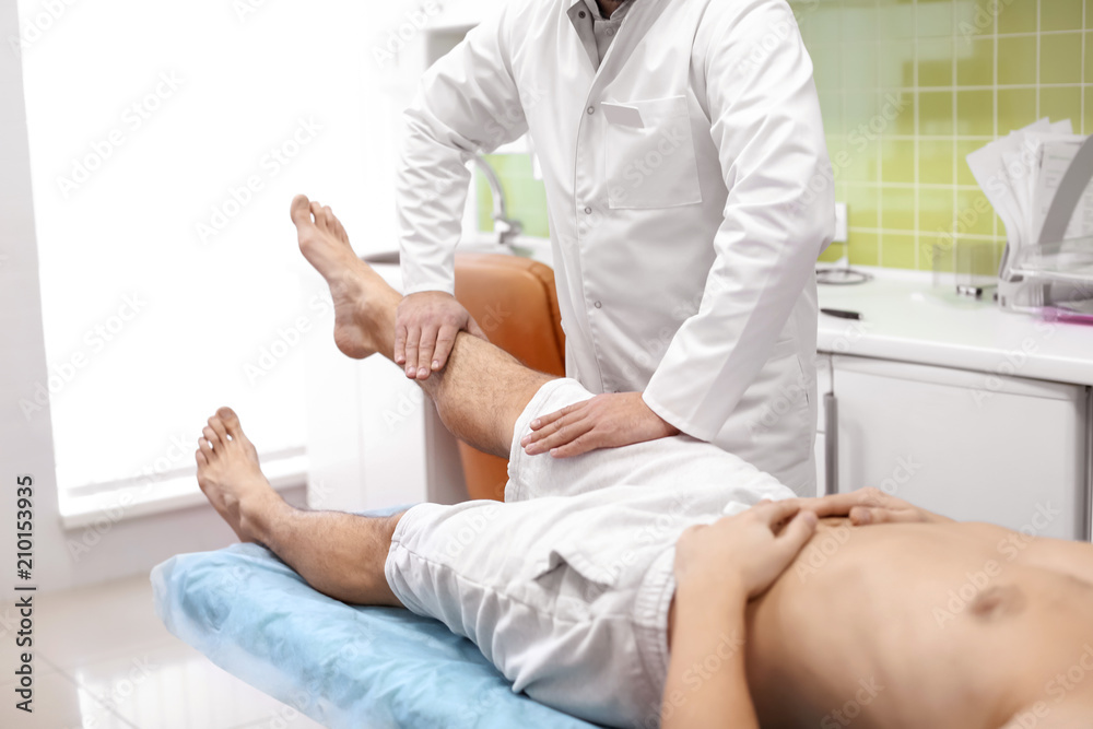 Orthopedist examining patient in hospital