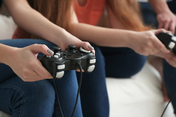 Young people playing video games at home, closeup