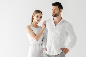 Wall Mural - attractive woman in linen white dress embracing boyfriend with hands in pockets isolated on grey background